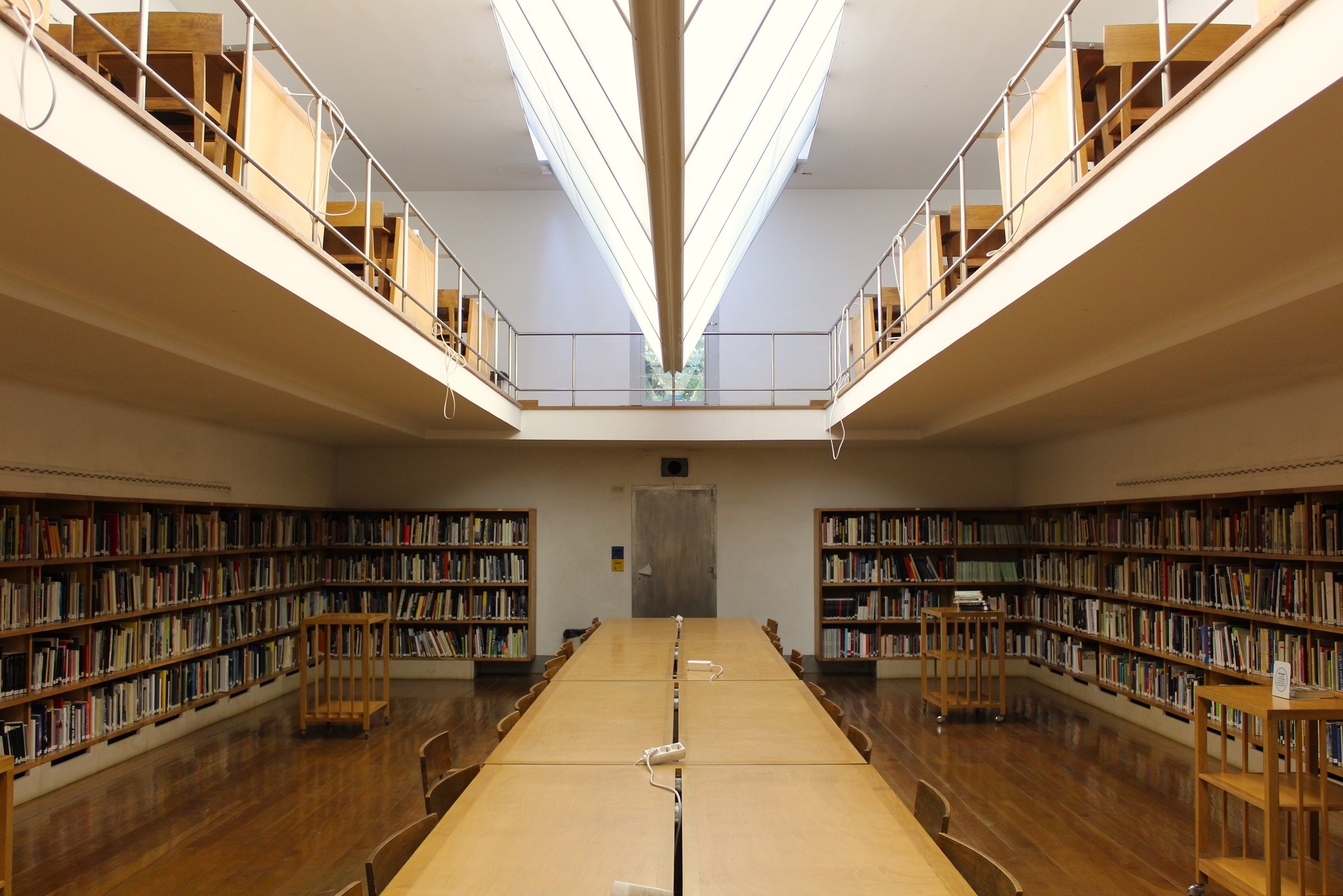 wide shot of a library hall with a table in the middle and books around the side