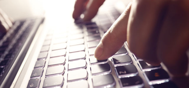 up close picture of fingers typing on a laptop keyboard