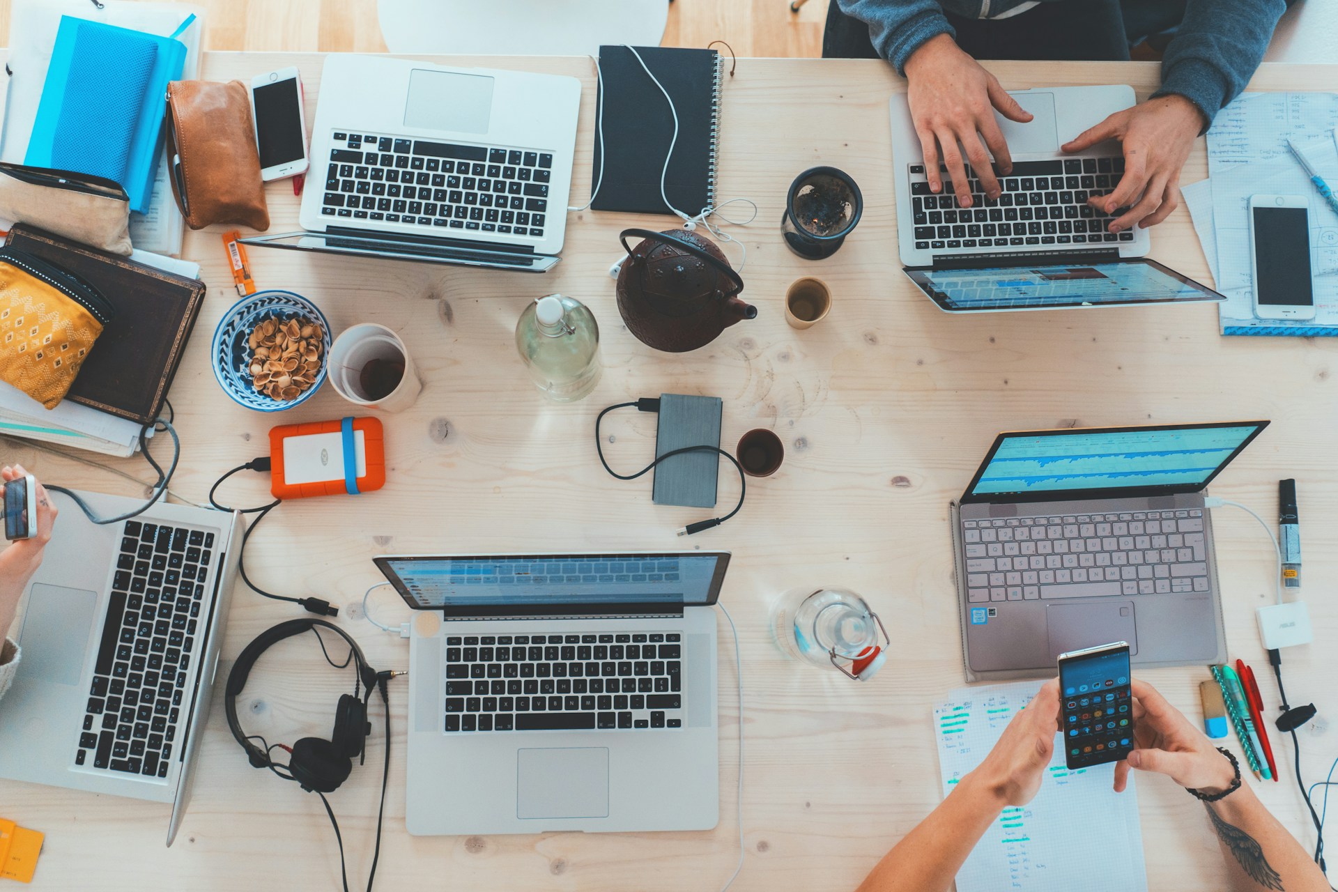 group of people working on laptops on a desk